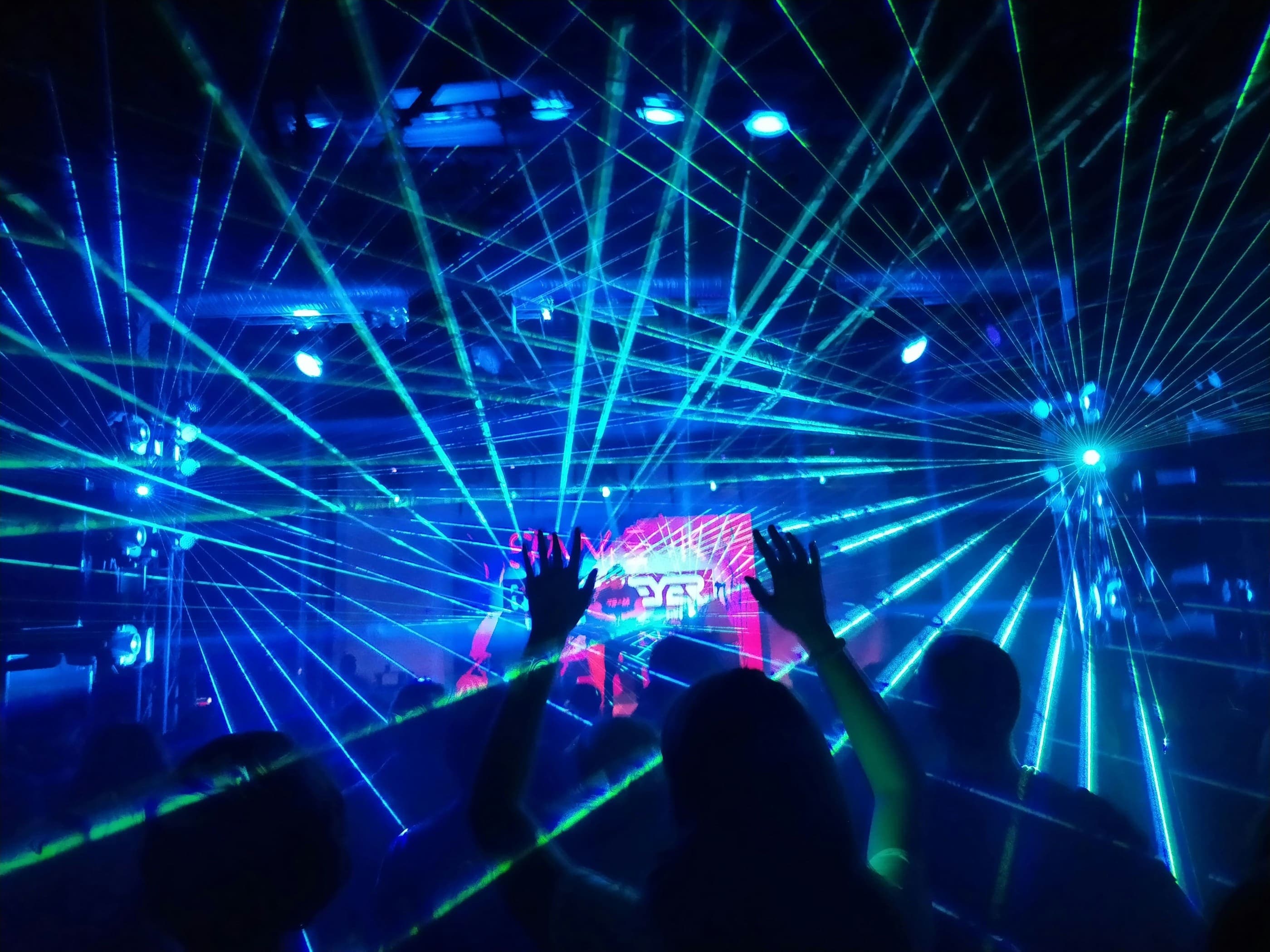Ravers dancing under lasers at a techno event featured in Techno Radar March 2026