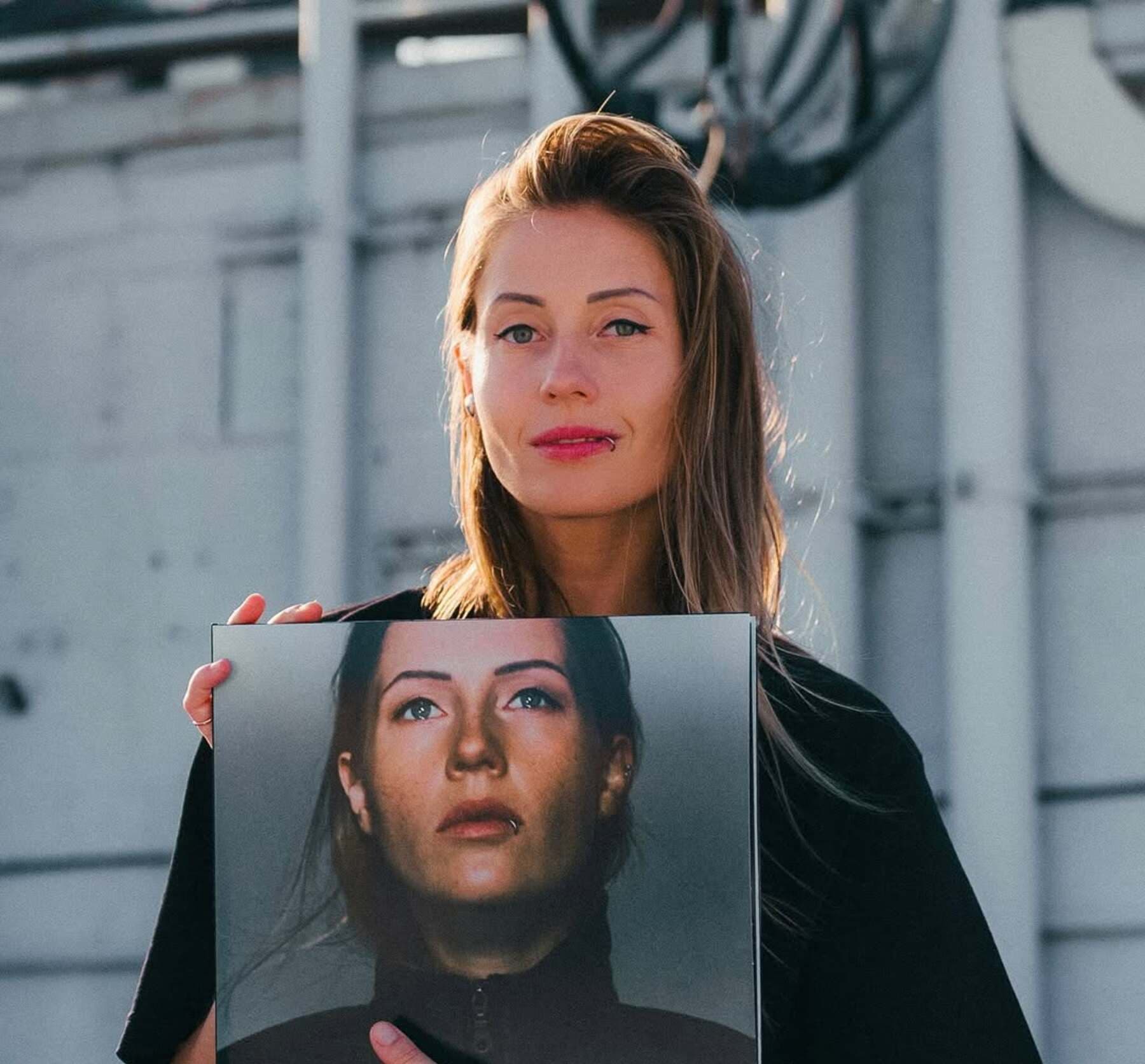 Charlotte de Witte holding a vinyl copy of her debut album Charlotte de Witte, released on KNTXT, photographed outdoors in daylight