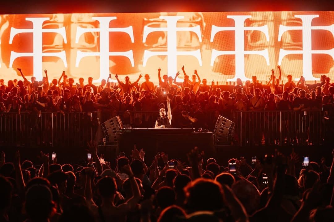 Crowd at Creamfields 2026 Teletech Arena with a DJ performing on stage, surrounded by intense red lighting and Teletech logos in the background.